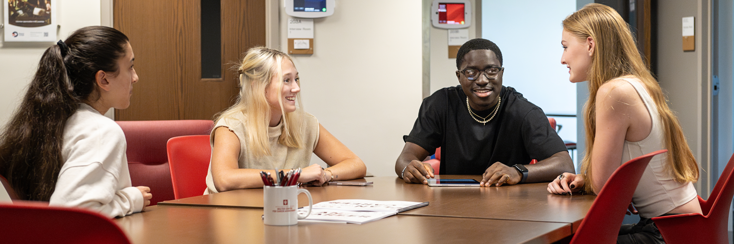 Four students discussing at a table